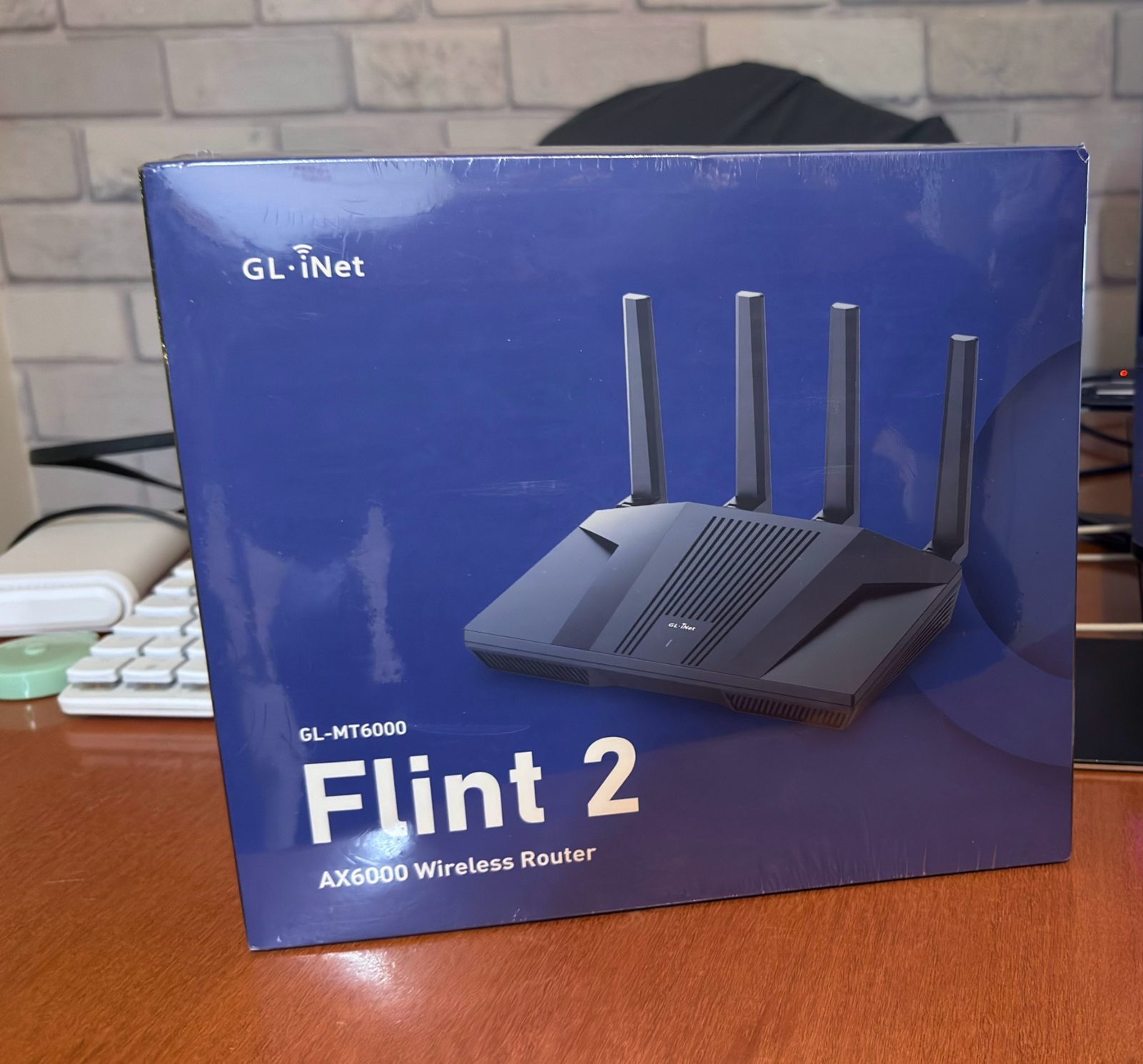 The GL.iNet Flint 2 GL-MT6000 AX6000 wireless router, still sealed in its blue box, on my desk.